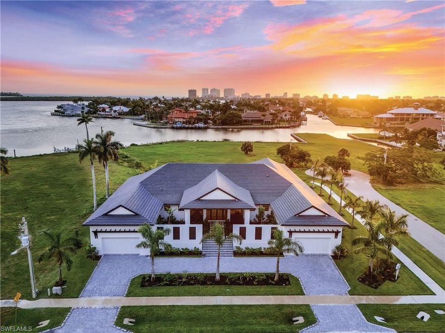 Move right into ultimate luxury in the Marco Island Estates section, in this contemporary coastal one-story oasis of 4697SF and 12,288SF total area including pool deck, 8,499 sq ft under roof for ideal indoor/outdoor living. An impressive foyer entry brings you to a 32'x20' great room featuring zero corner sliding walls and soaring windows for gorgeous light. From every room in the home, you are treated to sublime views of a double wide covered lanai with dual inlaid wood ceilings that overlook a resort style fenced yard, pool and integrated spa; with dual bubblers, and a sand beach sun shelf at one end, surrounded by lush tropical landscaping across the entirety of the pool deck. Featuring finished tray and volume ceilings, the great room living area is open to a sleek modern kitchen featuring a 12' x 5' island with veined quartz counters and matched backsplash, 5 seat breakfast bar, all custom cabinetry with undermount and upper cabinet lighting, walk-in butler's and service pantries leading to the formal dining area overlooking the pool. Relax and entertain friends and family in the spacious home theater with projector and surround sound; with candy bar, wine/bev fridge and powder room nearby. Also open to the lanai, retreat to the exclusive primary master suite wing with built-in's, his and hers walk-in closets and a beautifully appointed spa bath with wall-to-wall mirrors, built-in vanity, 6 ft. soaking tub and designer tile features. Adjacent is a wood lined study with coffered ceilings and lanai access. A second spacious split primary guest suite on the other side of the home features a large bath, walk-in shower, and walk-in closet. Partially furnished by Robb & Stucky, the furniture compliments the sleek lines of the home in a neutral palette. For further ultimate guest privacy, 2 more roomy cabana guest suites with private entrances overlook the pool and include large walk-in closets. Next to the cabanas is a full-size summer kitchen with an inlaid wood ceiling, a built-In grill and dining area for more entertaining. A large laundry room with built-in cabinetry is adjacent to a large mechanical room. This control 4 smart home includes lighting control, recessed and bespoke designer fixtures throughout. Dual garages with interior access and 4 car parking, flank the home with more parking on the circular drive. A contemporary coastal styling is felt through crown moldings, thoughtful wide plank wood-look porcelain, and stone tile flooring which enhance the clean lines and crisp interior design, creating a light and bright backdrop for the ultimate tropical lifestyle.