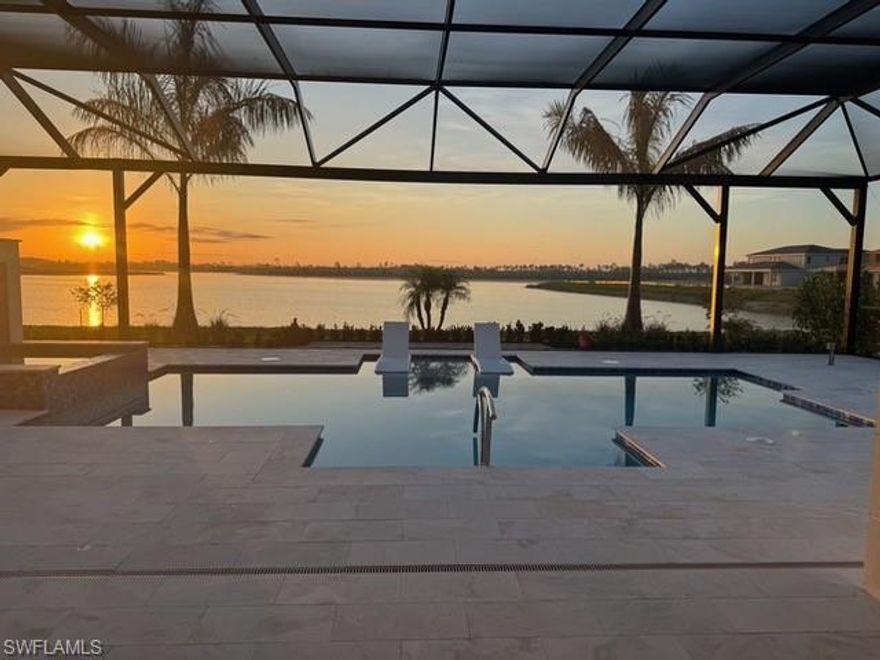 Perfectly positioned along one of the most coveted lakefront homesites within the newly established Seven Shores community, 9171 Wisteria Way showcases the highly sought-after Sarasota floorplan, offering three bedrooms plus a den, three and a half baths, and approximately 3,500 square feet of refined living space. Commanding panoramic water views stretch across the tranquil lake, creating a setting reminiscent of a private island retreat.

A welcoming foyer introduces the home’s expansive open-concept design, highlighted by soaring ceilings and upgraded wide-plank light oak flooring that enhances the bright, coastal-inspired interior. Floor-to-ceiling glass doors open seamlessly to the outdoor living area, blurring the lines between interior comfort and outdoor serenity while framing the breathtaking waterfront backdrop.

Designed for both everyday living and elegant entertaining, the great room flows effortlessly into the dining area and a beautifully appointed chef’s kitchen. This thoughtfully designed space features premium KitchenAid appliances, including a natural gas cooktop, shaker-style cabinetry, sleek quartz countertops, an oversized island, and a butler’s pantry that adds both convenience and functionality.

The outdoor living experience is equally impressive, offering a covered lanai with a linear fireplace, a fully equipped outdoor kitchen with upgraded pellet grill, and a resort-inspired saltwater pool and spa complete with sun shelf—all overlooking sweeping lake views and professionally enhanced landscaping.

The primary suite provides a peaceful waterfront sanctuary, featuring generous proportions, serene water views, dual custom walk-in closets by California Closets, and a spa-inspired bath with walk-in shower, dual vanities, and a private water closet. Two additional guest suites, each with access to their own baths and accompanied by a flexible sitting area, offer ideal accommodations for visitors, a home office, or fitness space.

Additional highlights include a mudroom with custom built-ins, a two-car garage with epoxy flooring and mini-split air conditioning, and the added security and convenience of a whole-house generator.

Seven Shores offers an exceptional lifestyle with a thoughtfully designed amenity center featuring a resort-style pool, clubhouse, tennis and pickleball courts, putting green, fitness center, and curated social programming led by a dedicated Lifestyle Director. Ideally located with convenient access to I-75, Southwest Florida International Airport, and Naples Airport, and just minutes from downtown Naples’ renowned beaches, fine dining, and luxury shopping, this move-in-ready residence represents a rare opportunity to enjoy elevated waterfront living in one of Naples’ most exciting new communities.
