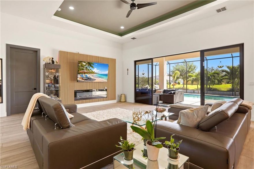 Welcome to Southwest Cape Coral luxury living. No flood insurance required. This exceptional four bedroom, two bath residence showcases sophisticated coastal elegance in one of the area’s most coveted neighborhoods. Located near premier shopping, entertainment, and convenient access to Cape Coral Parkway, this home offers the perfect blend of convenience and waterfront living on a freshwater canal ideal for fishing enthusiasts and boating adventures.
Inside, discover refined elegance with soaring tray ceilings and sophisticated lighting throughout the living spaces. The entertainment focal point features a textured accent wall with an elegant electric fireplace. Premium luxury plank porcelain tile flows seamlessly across the entire home, creating a cohesive, upscale aesthetic.
The gourmet kitchen is a chef’s dream, boasting ample cabinetry, high end fixtures, a generous island with stainless steel appliances, and top of the line finishes. The luxurious master suite features dual vanities, a freestanding soaking tub, and a spa like pass through shower. Two spacious guest bedrooms and a flexible first guest bedroom that doubles as a sophisticated office or den complete the layout. An in home laundry with generous storage adds daily convenience.
The outdoor living experience is truly exceptional. An expansive lanai spans the full length of the property, featuring gorgeous overhead plank wood ceiling and pavers throughout. An upgraded outdoor kitchen allows seamless entertaining and culinary enjoyment. The heated salt water pool and splash area provide year round enjoyment. East rear facing views deliver stunning sunrises perfect for morning coffee on your private patio. With Security cameras surrounding the property for peace of mind. a total of 2,219 living square feet and 2,816 total square feet, this three car garage home represents the pinnacle of Southwest Cape Coral.