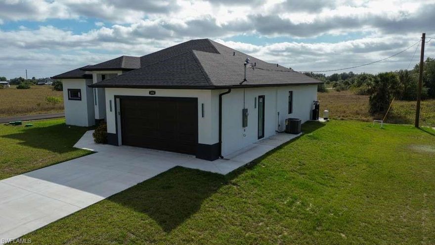 Beautiful and spacious corner-lot property located in one of the fastest-growing areas of Lehigh Acres.4 bedrooms and 2.5 bathrooms, offering 1,800 sq. ft. of air-conditioned living space. This home features premium finishes, unique upgrades including interior glass doors, a modern kitchen with stainless steel appliances, and comes with a one-year builder warranty. The spacious open floor plan is perfect for family living, complemented by a 2-car garage with tiled flooring and a screened terrace, with pre-wired connections available for an outdoor kitchen.  Conveniently located near schools, shopping.