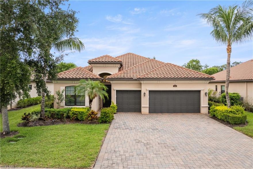 Refined contemporary finishes and the effortless indoor-outdoor lifestyle synonymous with Southwest Florida living come together in this beautifully updated 4-bedroom, 3-bath residence in Treviso Bay. The home’s clean architectural lines, manicured landscaping, and expansive paver driveway establish a polished, upscale presence, while inside, light-filled interiors and thoughtfully curated upgrades create a warm yet elevated atmosphere throughout. Recent enhancements include WiFi-controlled hurricane shutters, a WiFi-enabled thermostat, and resurfaced pool, lanai, and driveway areas. Designer furnishings throughout and high-end lighting fixtures complement the wide-plank wood-style flooring, plantation shutters, soft neutral palette, and custom feature walls that collectively create a polished, magazine-worthy aesthetic. The spacious open-concept layout unfolds beneath tray ceilings and flows seamlessly into the heart of the home—a beautifully appointed kitchen featuring quartz countertops that continue seamlessly to the backsplash and oversized island, abundant cabinetry, stainless appliances, designer lighting, and an adjacent breakfast nook and formal dining area. Pocketing sliders extend the living spaces outdoors to an expansive screened lanai designed for year-round enjoyment. A built-in summer kitchen anchors the covered lounge area, while the resurfaced lagoon-style pool and elevated spillover spa are framed by tropical landscaping, manicured hedging, and generous open-air lounging space that captures the essence of private resort living. The spacious primary suite is highlighted by custom millwork and a well-appointed ensuite bath. A thoughtfully designed split-bedroom floor plan enhances privacy, with two guest bedrooms sharing a dual-sink bath while the fourth bedroom—currently utilized as an office—enjoys access to its own full bath, offering ideal flexibility for guests or remote work. A spacious 3-car garage completes the offering. Treviso Bay delivers one of Naples’ most coveted resort lifestyles, centered around a championship TPC golf course and an extraordinary amenity collection that includes a grand clubhouse, resort-style pool with poolside dining, tennis, pickleball, fitness center, spa services, walking and biking trails, and a vibrant year-round social calendar. Ideally positioned between downtown Olde Naples and Marco Island’s white-sand beaches, the community offers exceptional proximity to fine dining, boutique shopping, entertainment, and the very best of Southwest Florida’s coastal lifestyle.