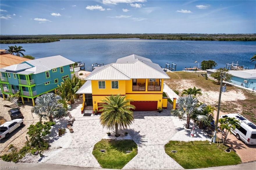 This unique custom-built waterfront home offers direct access to the Gulf of Mexico and boasts expansive water views that are sure to impress. BUILT IN 2020, this property features multiple balconies, decks, and rooms designed to capture Matlacha's serene coastal vibe. Situated on direct Gulf access with no bridges to slow you down, the home includes a new SEAWALL with a TREX DOCK and a COVERED 10,000lb BOAT LIFT, providing  convenient storage and protection, all right in your own backyard.

Upon entering through the leaded glass doors, you will be greeted by the warmth of sunlight reflecting off the stunning custom-designed epoxy flooring that flows throughout the main floor. The main floor features a divided primary bedroom with an en-suite and access to the private Orchid deck. The west facing primary offers direct access to the pool deck and the screened lanai which features ELECTRIC ROLL DOWN SHADES for easy sun control. The main floor also includes a laundry area, open concept kitchen, dining, and living areas. The spacious Chef's Kitchen features beautiful maintenance-free CAMBRIA QUARTZ countertops and top-of-the-line BLACK STEEL appliances. Family and guests can enjoy socializing with the cook while seated at the EXPANSIVE serving island before heading to the lanai and pool deck to savor the breathtaking water views.

Upstairs, a spacious family room awaits, accessible by a PRIVATE ELEVATOR. The second floor includes a  primary bedroom with an en-suite and a sitting area. There is also a second-floor laundry, a bonus area, observation deck, a family room with kitchen facilities, and a screened porch also outfitted with electric roll-down shades. There are two additional bedrooms, one with an en-suite and the other bedroom with easy access to the screened balcony at the front of the house. It's always fun to watch the boats head out Matlacha Pass while enjoying your morning coffee and watching the sunrise! 

The bottom ground floor features a three-car garage/workshop designed to function seamlessly in the event of severe weather. All important elements such as A/C, electric, and plumbing are raised high along block walls to avoid impact from severe weather. Additionally, there is no sheetrock, only cement block.

This property offers a one-of-a-kind Matlacha living experience, combining luxury, convenience, and coastal charm in a picturesque waterfront setting.