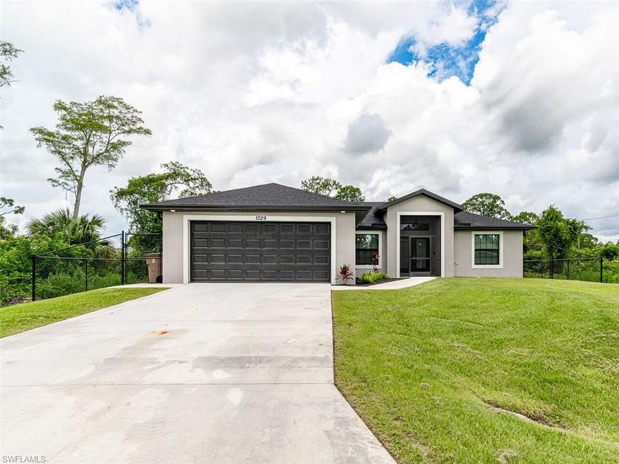 This charming 3 bedroom, 2 bath single family home is located in Lehigh Acres. Conveniently located in a quiet neighborhood with no HOA fees. The home was built new in early 2020.  The current owners upgraded several things to this new home to make it even better.  Inside the home, they added custom lighting and dimmers throughout.  They installed custom windrow treatments and repainted the entire interior with a high quality gloss paint to add durability. In the kitchen, they added a custom tile to the island and also installed a tile backsplash. On the exterior for the home, they installed a fence to fully enclose the back and side yards, installed full matching color gutters and downspouts, and epoxy finished the garage floor.  There is also a 4 stage sprinker system to help maintain the immaculate lawn front and back!  They current owners also installed a screened in lanai to enjoy the quiet evenings outside.  No detail was missed on this home!  Don't miss the opportunity to own this new home with all the upgrades, it won't last long!