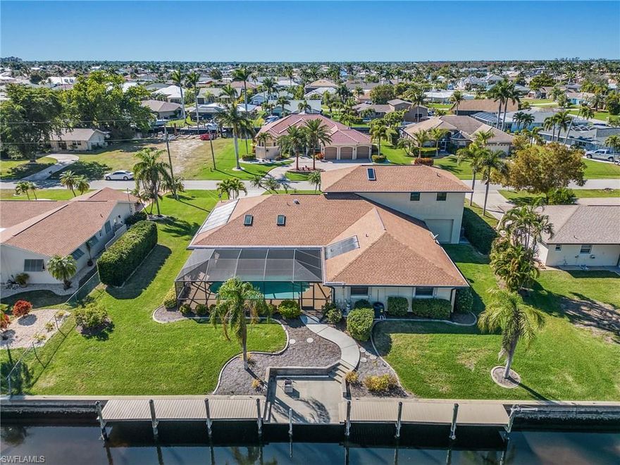 Unique home ON 3 LOT SITE/ TOTAL A/C AREA 4,373 SQ FT. Downstairs features a primary ensuite bedroom on the south side with sliders to the pool.On the opposite side are two guest rooms downstairs (one 20 X 13) and a full bath that also serves as a pool bath. The huge great room has a Cathedral ceiling, impact glass windows and sliders to the lanai and pool area. There is also an office or hobby room. The huge dining or flex room with a large bay window and breakfast room overlook the pool and canal. The kitchen has new wood cabinets and granite counters with a view of the pool area and a bay window in the breakfast nook. Upstairs there are 3 large bedrooms, 2 walk-in closets, bay windows, a balcony, full bath and pull down stairs to the attic as well as walk in attic access. 722 sq ft of 2 car garage + work shop and laundry are under central air for comfort year round and the 323 sq ft garage has a window unit to maintain humidity for storage and a front and rear overhead door for ease in loading your boat equipment and toys. The under roof lanai is over 624 square ft of entertainment area with a pass thru window from the kitchen and a granite bar and almost 1,500 sq ft of total lanai and pool area.Pool heated via solar and heat pump. Amazing extended living space year round with South/Eastern exposure. Accordion Shutters enclose the covered lanai and protects this outdoor living space regardless of the weather.  Just a short ride to Tarpon Point river access! TREK DECK DOCK AND CAPTAINS WALK
Check room sizes in listing. Not your cookie cutter home.
Flood policy is renewable 2/2025, transferrable and current rate $1,075.00 annually
