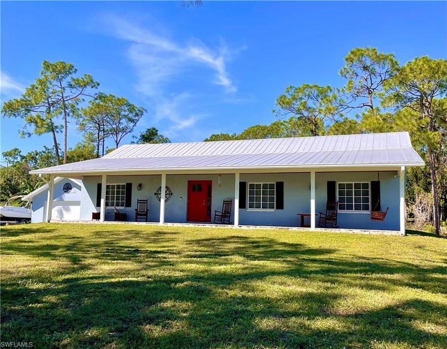 Truly a one-of-a-kind property!  This stunning custom designed and built by owner home is located in the highly sought after development of San Carlos Estates Bonita Springs.  The floor plan offers 3 bedrooms, 2 full bathrooms, a bright open concept kitchen great room area, and a laundry/mudroom which includes an extra walk-in shower.  Step out the front door to the expansive front porch with river rock flooring and cypress wood tongue and groove ceiling.  Property also features a 24 x 30 square foot 2-car garage and a 16 x 20 square foot metal barn with a poured concrete floor all situated on a 1.25 acre lot.  House has septic system and is connected to city water.  Also has a deep water well.  Metal roof was added to house in 2018, and garage metal roof was replaced in 2019.  Home was fully remodeled in 2021 to include quartz countertops, upgraded stainless steel GE Profile appliances, Ring Doorbell, and many more upgrades.  Metal barn was built in 2023.  Full HVAC system replacement including air ductwork, vents, and thermostat was completed in May 2024.