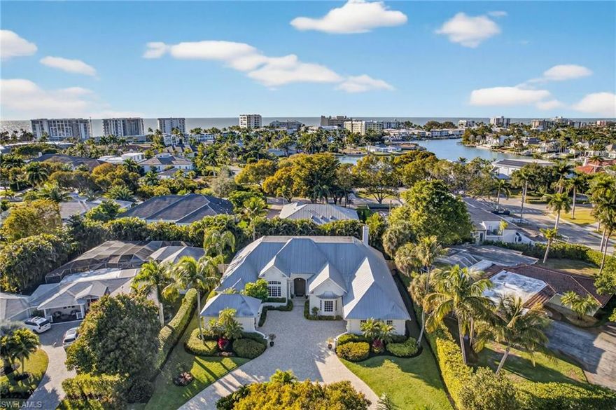 Discover refined coastal living in this elegant residence ideally situated in the heart of Coquina Sands, just moments from the beach and the new Naples Beach Club, a Four Seasons Resort. Thoughtfully designed for both sophistication and comfort, this 4-bedroom, 5-bath home with a den and private office features a light-filled, open floor plan highlighted by vaulted ceilings and French doors that open to a west-facing lanai overlooking the pool and spa, framed by lush tropical landscaping.

The owner’s suite is a serene retreat with direct lanai access and a spa-inspired bath complete with a private courtyard, dual vanities, soaking tub, walk-in shower, and two custom walk-in closets. The chef’s kitchen is beautifully appointed with a six-burner gas range, wall oven, and dual dishwashers, flowing seamlessly into the dining area accented by a fireplace—ideal for both intimate gatherings and entertaining.

Natural light fills every space, from the main living areas to the en-suite guest bedrooms, office, and den, creating a warm and inviting atmosphere throughout. Notably, the home was never affected by any of the recent hurricanes, further underscoring its quality construction and desirable location. Additional highlights include a 26kW Generac generator, climate controlled garages, and two newer HVAC systems, offering comfort and peace of mind year-round. Offered furnished with exclusions, this home delivers timeless elegance and effortless coastal living in one of Naples’ most coveted neighborhoods.