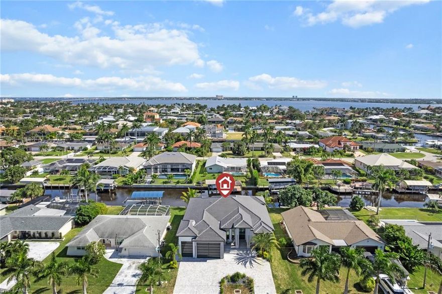 New Construction with Direct Sailboat Gulf Access in the Cape Coral Yacht Club. 2025 luxury waterfront estate designed for serious boaters and coastal living. Located in the heart of the highly sought-after Yacht Club district near Cape Coral’s only beach, this modern residence offers true direct sailboat Gulf access with fast, no-bridge boating to the Caloosahatchee River, Sanibel, Captiva, and the Gulf of America. Offering 3,015 SF and over 5,700 total SF, this 4-bed plus Office waterfront home features 4 private en-suite bathrooms, a dedicated office, and a three-car garage. Designed for both full-time residents and luxury seasonal buyers, the open concept floor plan showcases 15.4-foot coffered ceilings, 10-foot impact glass sliders, expansive water views, and seamless indoor outdoor living. The great room is awe-inspiring with large-format tile flooring, a designer feature wall with a fireplace, and zero-corner disappearing sliders. Over $100,000 in premium upgrades elevate this home above comparable new construction in Cape Coral. The chef’s kitchen includes custom cabinetry, a waterfall island, a luxury appliance package, a pot filler, a hidden butler’s pantry, and a built-in bar area ideal for entertaining or wine storage. The dining space captures views through a dramatic bay window. The primary suite offers a true five-star retreat experience, featuring tray ceilings, pendant lighting, French doors to the lanai, dual vanities, and a walk-in shower. A VIP waterfront guest suite functions perfectly as a 2nd master. Outdoor living defines the Gulf access lifestyle. Enjoy a custom heated saltwater pool with sunshelf, LED lighting, nearly 700 square feet of covered lanai, and summer kitchen. Built to current 2024 and 2025 construction standards with an elevated foundation approximately 1.5 feet higher than prior builds, hurricane impact windows and doors, and flat tile roof construction, this home provides enhanced storm protection & potential insurance advantages. What truly sets this property apart is its location within Cape Coral’s most dynamic waterfront redevelopment corridor. The transformational Yacht Club Beach and Marina renovation will introduce new resort-style pools, expanded marina facilities, waterfront dining, boutique retail, and community gathering spaces. Just minutes away, The Cove at 47th - downtown Cape Coral’s walkable dining and entertainment district, featuring Oak & Stone, rooftop bar, Aqua Seafood & Steaks, Big Nick’s BBQ, and Seed & Bean Market. Bimini Square, a landmark mixed-use waterfront development, includes Bimini Basin Seafood & Cocktails, House of Omelets, boutique retail, and Lee Health medical facilities. The area is designed as a true live-work-play! With Tarpon Point Marina, The Westin Cape Coral Resort, Palmetto Pines Country Club, and Coral Oaks Golf Course all nearby, this home places you at the center of boating, dining, entertainment, and growth.