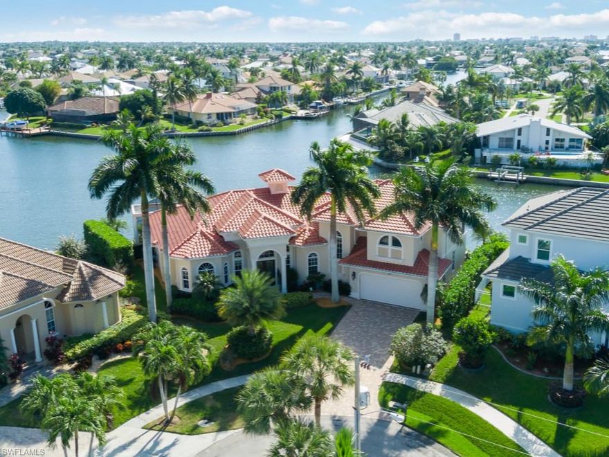 Look no further, this stunning 2-story residence with 4 bedrooms & a den was built on a trophy lot with popular southern exposure, a double-wide waterway & several full converging waterways to enhance the exceptional Marco skyline views & deliver privacy!  This home is offered fully furnished, the great room floor plan has soaring ceilings, custom cabinetry & built-ins, extensive mill work, a massive kitchen & dining area, plus a family room upstairs with a huge balcony to enhance the guest quarters.  Great for entertaining, on the lanai you'll enjoy an infinity edge pool with spa, fireplace & summer kitchen.  Rarely found, enjoy a spacious 4-car garage with extra garage door on the water side for easy access to the waterfront.  This perfect tip lot & water indirect location is terrific for boaters as the only bridge out is new with over 14' height & 60' width, to accommodate large boats. There is a maintenance-free U-shaped dock & lift along the massive 162' seawall.  Newer roof, newer seawall, well-maintained & exceptional, so hurry!