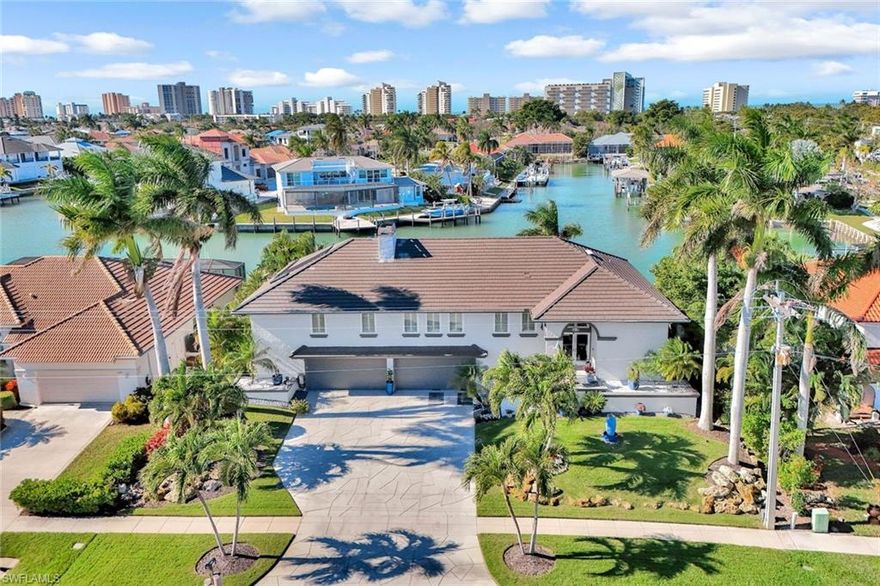 Exceptional waterfront residence that offers deep-water, direct Gulf access and breathtaking, extra-wide west water views—an ideal setting for serious boaters and yacht owners. This expansive 3-bedroom plus den, 3.5-bath pool home with 4-car garage represents a rare opportunity and one of the best values on the island.
Thoughtful renovations elevate every inch of this home, beginning with imported Brazilian custom teak flooring that flows throughout. The residence is fully equipped with impact-rated windows and sliders, recently replaced multi-zone air conditioning systems, a new whole-house central vacuum system, plantation shutters throughout, two fireplaces—including an electric fireplace in the living room and a wood-burning fireplace in the primary suite—and custom closet organizers. The roof was replaced in 2018, and the water heater was updated in 2023. The home is also designed with space allocated for a future elevator, with an estimated cost of approximately $16,000.
The updated kitchen features new backsplash and upgraded outlets, premium imported Italian PVC cabinetry with pull-out storage and soft-close drawers, high-end granite countertops with striking natural character, a full suite of high-end appliances, including Jenn-Air selections, and a Fisher & Paykel double dishwasher. A spacious walk-in pantry provides exceptional storage and functionality. The primary suite serves as a serene escape with a jetted therapeutic soaking tub, while a secondary primary suite provides added flexibility. The guest suite is enhanced by a custom steam shower, offering spa-like comfort for visitors. Outdoor living is an entertainer’s dream, centered around a spacious screened-in lanai with roll-down screens, and Brazilian hardwood decking that has been recently redone and fully waterproofed. The two-year-old solar-heated saltwater pool features a modern saltwater filtration system and is surrounded by a generous deck designed for relaxed gatherings, plus a covered lanai also with roll-down screens. Boaters will appreciate the expansive dock complete with two lifts, a 15,000-pound lift, and a platform lift for jet skis, small boats, and kayaks. Deep-water access is perfectly suited for large yachts or sailboats. The home is elevated for lower flood risk, the expansive garage also provides ample storage and a dedicated workshop, completing this extraordinary waterfront offering. Set in one of Marco Island’s most sought-after walk-to-the-beach locations, this remarkable residence places you minutes from the white-sandy beaches, world-class boating, and the vibrant dining, shopping, and entertainment that define island living.
