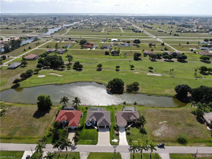 Lowest priced new construction home on any golf course in Cape Coral..NO HOA FEEl!! CUSTOM BUILT NEW CONSTRUCTION ON CORAL OAKS GOLF COURSE WITH SWEEPING LAKE AND FAIRWAY VIEWS!! Stunning 3 bedrooms plus den and 2.5 baths with nearly 2200 sq. ft. of living space. Open floor plan with custom kitchen that includes stainless appliances, soft close cabinets with granite & center island, huge walk-in pantry, coffered ceiling in great room and engineered vinyl wood plank flooring throughout!!! Large master suite with beautiful master bath that includes dual sinks, shower and soaker tub. Separate guests rooms, guest bath and private den. Beautiful fans and lighting throughout, 3 car garage, IMPACT WINDOWS AND DOORS and paved drive way. WALK OUT TO THE HUGE LANAI THROUGH THE POCKET SLIDERS, 2 UNDER TRUSS AREAS WITH PAVERS,OUTDOOR KITCHEN AND LARGE POOL WITH POOL BATH.. Buyer to receive a free 1 year golf membership to Coral Oaks Golf Course with sale of home!! Enjoy golf course living with no HOA fees. Home comes with builder warranty.