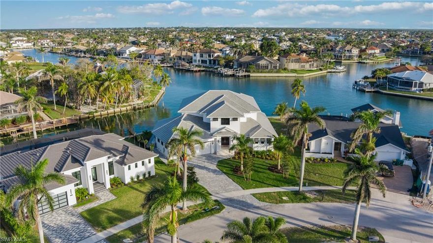 Pull your boat up to the new seawall at this extraordinary new residence located on a massive water indirect lot w/fast boating access through Robert's Bay to the Gulf! Enjoy the sunny SE exposure lanai w/large covered area, incredibly vast open pool deck, awesome pool w/spa, outdoor living room w/outdoor chefs kitchen, refrigerator, grill, powerful vent, dishwasher, farmers sink & island, plus electric roll down screens/shutters to complete the superior outdoor living package! This residence offers the finest in coastal living with 4,443 s.f. of a/c luxury, all professionally designed, offering high-end wood flooring throughout the main living areas, a first floor master suite w/dreamy bath, walk-through shower & a huge his/hers custom closet. This 2-story, great room floor plan has a dreamy gourmet kitchen w/custom Amish cabinetry, beautiful quartz countertops, large walk-in pantry & lovely island, plus custom living area ceiling finishes. Upstairs guests will enjoy 3 bedrooms/3 baths, a family room, covered lanai w/magnificent views of the waterfront! There is a tackle/storage room & a 3+car garage to complete the package!