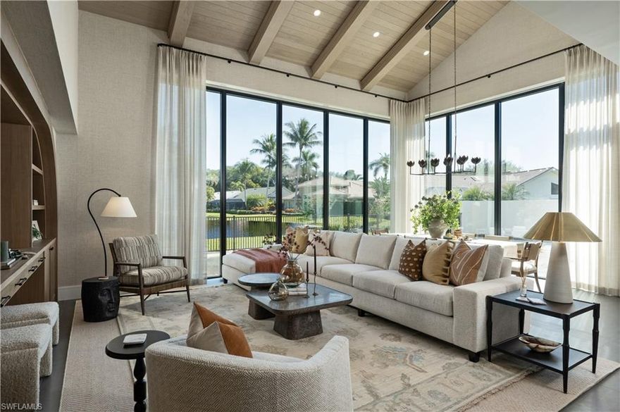 This extraordinary under-construction lakefront estate, completing in March, in the prestigious enclave of Las Brisas is a residence that cannot be replicated. Designed with architectural intention and curated to perfection, it represents a rare convergence of craftsmanship, setting, and interior artistry. A collaboration among Naples’ premier luxury design professionals—architecture by Beck Architectural Group, construction by Knauf Koenig Group, pool and landscape design by The Max Gooding Company, and interiors by Calusa Bay Design—the result is a home of exceptional pedigree and enduring quality. A private gated courtyard sets the tone, leading to a dramatic mahogany-and-glass entry. Inside, 18-foot ceilings define the two-story great room, where floor-to-ceiling glass captures uninterrupted views of the tranquil, tree-lined lake. White oak beam accents, a custom feature wall, and large-format basalt tile flooring create a refined yet welcoming aesthetic. Hand-knotted rugs, bespoke furnishings, and layered detailing by Calusa Bay Design add understated sophistication, while textured wall coverings bring warmth and an effortlessly chic feel. The first-floor primary suite is a private sanctuary with serene lake views framed by walls of glass. The spa-inspired bath features exquisite tilework, custom cabinetry, an oversized shower, sculptural soaking tub, dual vanities, a private water closet, and twin custom wardrobes — designed for both indulgence and function. The open living area flows into a chef’s kitchen appointed with custom Ruffino cabinetry, a waterfall island, professional-grade Thermador and Sub-Zero appliances, an integrated wine refrigerator, and a conversation lounge overlooking the 40-foot resort-style pool and lake. Indoor and outdoor living blend seamlessly, with a screened lanai extending the gathering spaces for year-round entertaining. The courtyard and rear exterior are anchored by the 40-foot pool with integrated spa, set against a peaceful lakefront backdrop that feels private and cinematic. A white oak and glass staircase leads upstairs, where open-to-below elements enhance light and volume. Three guest suites, each with walk-in closets, are complemented by two guest baths, ensuring comfort and privacy. Modern luxury is seamlessly integrated, including a Lutron whole-home lighting system, impact-rated windows and doors, a concrete barrel tile roof, and a two-car garage with resilient floor coating. Residents enjoy access to Pelican Bay’s private beachfront amenities — three miles of beach, beachfront dining, a state-of-the-art fitness center, 18 Har-Tru tennis courts, and pickleball courts — minutes from Waterside Shops, Artis–Naples, and Naples’ premier dining and boutiques. First floor offered furnished, this exceptional property delivers elegance, comfort, and an unmatched location — the ultimate Naples lifestyle. This is more than a home — it is a curated lakefront experience. Architectural, refined, and truly rare.