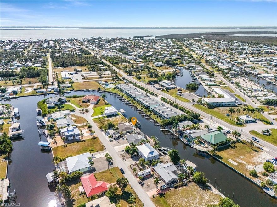 Are you tired of shoveling snow already?  Then don't let this beautiful waterfront pool home with quick access to the Gulf of Mexico with no bridges or locks get away!  This 3 bedroom/2 bath/2 car garage home has some furnishings that are negotiable!  This home boasts: new vinyl seawall (by Honc) replaced in 2014, new screened pool in 2019, new roof in 2023, new electrical panel, new laminate flooring, no copper piping, newer almost 80' long composite dock and 7K pound lift, with water, electric and a fish cleaning station.  Why wait to build, when you can move right in at closing?  There is no mandatory HOA, and no restrictions, so you can leave your boat/trailer/RV next to your home.  And, think of the money you will save by not having to pay for lawn maintenance with the stone yard!  There are fruit trees on the property, and I hear the mangoes are delicious!