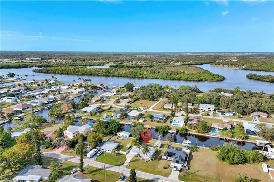 GULF ACCESS AT AN UNBEATABLE PRICE! This beautifully remodeled 2-bedroom, 2-bath home with a 1-car attached garage, setting on an oversized lot, offers the ultimate Southwest Florida boating lifestyle with your private boat dock and lift and just one turn to the Caloosahatchee River. Recent upgrades include a brand new elevated 2025 AC system, 2023 water heater, 2018 roof, upgraded granite countertops with stainless steel appliances, and a fully remodeled primary bathroom, giving the home a fresh, modern feel throughout. Inside you’ll find luxury vinyl plank flooring throughout with tile in the kitchen, along with a spacious family room addition filled with natural light and featuring impact windows and doors, while the remainder of the home is protected with aluminum hurricane panels. The kitchen showcases wood cabinetry, granite countertops, and upgraded appliances, while the beautifully updated primary bath features a sleek modern shower. Step outside to a large screened lanai and a spacious fenced backyard where you can enjoy peaceful waterfront living, fish right from your dock, or take in breathtaking sunset views. The backyard also features a convenient detached workshop/garage, providing additional storage and flexibility. Perfectly positioned in a quiet setting while still close to shopping, dining, and everyday conveniences, this home offers an incredible opportunity to own Gulf access living at an exceptional value.