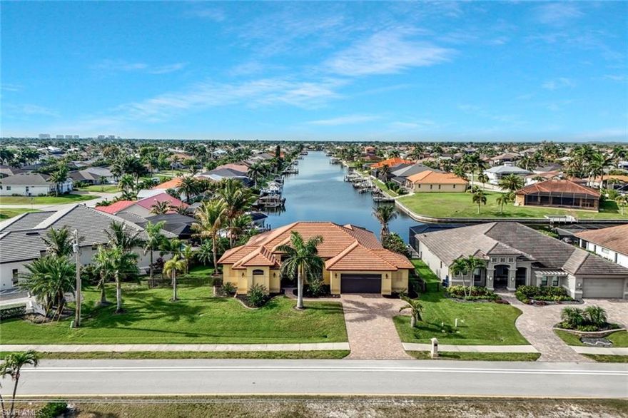 Welcome to your front-row seat to the ULTIMATE FLORIDA LIFESTYLE. This 2,444 sq ft, 3 bedroom, 2.5 bathroom, 2.5 car garage residence is situated on an *OVERSIZED LOT* (over 13,000 sq. ft.) that boasts the highly coveted *SOUTHERN REAR EXPOSURE*. This orientation ensures your outdoor oasis is bathed in sunlight all day long, providing the perfect climate for year-round enjoyment. The focal point of this property is the *DRAMATIC, LONG-RANGE VIEW STRETCHING STRAIGHT DOWN THE WIDE CANAL*, offering a sense of *DEPTH AND PRIVACY* that is *RARELY FOUND ON THE MARKET*. Curb appeal is immediate, with a tile roof, paver driveway, screened entry and professional landscaping; enclosed by a metal fence for added security and style.

The interior of the home reflects a commitment to quality, featuring elegant travertine flooring throughout the entire living space, impact windows, volume ceilings, and lots of natural light. The kitchen is a standout, outfitted with granite countertops, wood cabinetry, and stainless steel appliances that cater to both daily life and entertaining.  Practicality meets luxury in the oversized 2-car garage, which includes a climate-controlled storage space—the perfect solution for preserving sensitive items in the Florida heat.

Step outside into your private sanctuary, where a sleek 42' lap-style pool is framed by an expansive brick paver lanai and a matching paver walkway that wraps around the entire pool perimeter. To ensure nothing competes with the stunning water views the pool cage features picture-frame screening, while roll-down hurricane screens provide storm protection. For the boating enthusiast, the property features a large dock with a 10k lb boat lift, offering a gateway to the Gulf. Whether you are navigating the open water or enjoying the serenity of your landscaped grounds, this home delivers an unparalleled experience in one of the most sought-after waterfront settings.  Assessments Paid and Seller Flood Insurance is transferrable!