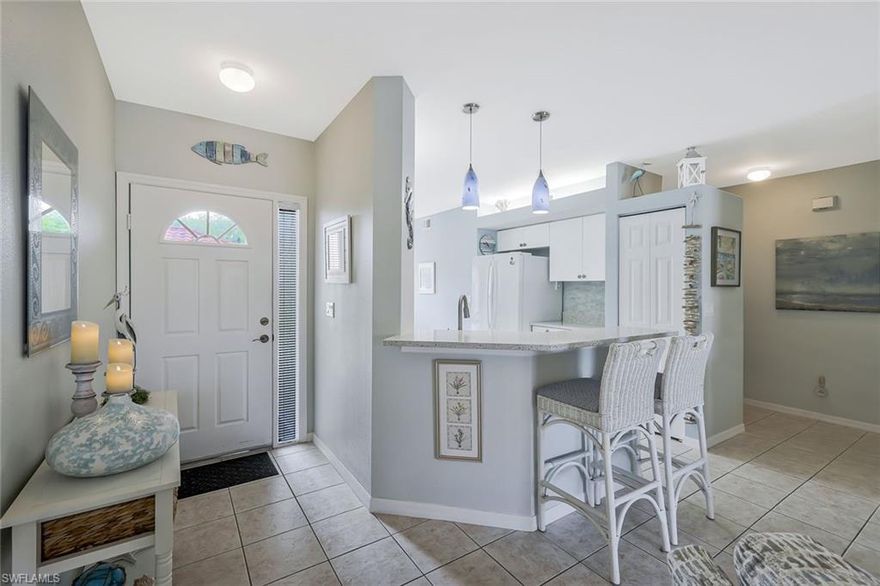 Welcome to this beautifully maintained first-floor 2-bedroom, 2-bathroom condominium, where comfort meets effortless Florida living. A soothing light gray interior palette creates a fresh, modern feel throughout, complemented by tile flooring in the main living areas, wood-look vinyl in the spacious primary suite, and carpet in the guest bedroom. The stylish eat-in kitchen is both functional and inviting, featuring sleek quartz countertops, crisp white cabinetry, matching white appliances, and a pantry for ample storage. The open layout flows seamlessly into the living space, perfect for everyday living or entertaining. Retreat to the primary suite, complete with private lanai access through sliding glass doors, creating the perfect indoor-outdoor connection. The ensuite bath offers dual sinks and a large walk-in shower. Step outside to your west-facing screened lanai, where you can unwind and enjoy serene lake views highlighted by a charming fountain—an ideal setting for soaking in breathtaking sunsets and the peaceful surroundings. You will appreciate the added protection of stone-coated steel roofs installed community-wide in 2020. Located within the gated community of Lighthouse Bay, residents enjoy exceptional resort-style living with access to five swimming pools, including a lap pool, 2.5 miles of scenic walking and jogging paths, tennis courts with a pro on staff, a robust bocce program, two boat houses, a fitness center, sauna, clubhouse, library, and an Arts & Learning Center. As an added bonus, a Bronze Membership to the Brooks Commons Club is included, granting access to a private restaurant, enrichment center, pickleball, and vibrant social programs. Gold Memberships are available for upgrade, providing access to The Commons Club Private Beach with chaise lounges, umbrellas, an ice/water dispenser, conveniently located restrooms, and Beach Parking Reservations during the construction of the new club. Ideally located just minutes from Coconut Point Mall, dining, entertainment, Southwest Florida International Airport, and pristine Gulf beaches!