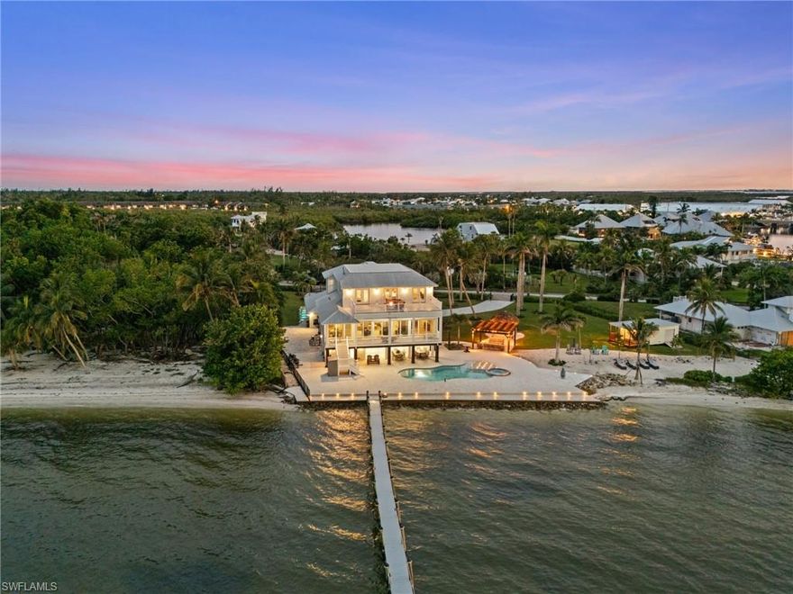 Experience the pinnacle of coastal luxury on Charlotte Harbor with this extraordinary estate, just 15 minutes from the famous Boca Grande Sandbar and some of the best tarpon fishing waters in the world. This home offers over 5,000 square feet of living space elevated above the flood zone and an astounding 227 feet of water frontage, making it one of the most in demand waterfront lots on Pine Island. With panoramic water views reaching up to 17 miles across the harbor, this home captures the true essence of Florida living, blending elegance, comfort, and unparalleled natural beauty.

A recently built pool with an infinity-edge spa (completed in 2020) sets the tone for the home’s resort-style atmosphere, surrounded by lush landscaping, mature palms, and a trellis-covered walkway. Outdoor living is elevated with a fully equipped tiki bar, a large paver deck, landscape lighting, and a 300-foot private dock complete with a boat lift, included boat, and room to accommodate additional lifts. The gated and fenced yard adds both privacy and security, while two raised-platform generators and smart-metered propane tanks ensure year-round peace of mind.

In 2021 this home was completely redone from the ground up. Inside, every detail has been thoughtfully curated. The expansive open-concept main floor features shiplap accent walls, woodgrain ceiling fans, and recessed wood panel ceilings throughout all five bedrooms. The living area centers around a dramatic Hellfire 360 contemporary fireplace, creating a warm and stylish focal point. The chef’s kitchen impresses with a massive Thermador refrigerator that blends seamlessly with custom cabinetry, an oversized island with integrated accessories, and a built-in bar perfect for entertaining. Speaking of fun, there's an additional 2,996 sq feet of finished space under air with full bathroom on the ground level making it perfect for unwinding after time at the beach.

Each of the six bedrooms includes a full en-suite bathroom, and the master suite is a private retreat featuring a gas fireplace, a freestanding soaking tub, and a spacious walk-in shower with multiple heads, including a rain feature. Natural light pours into the home through impact-rated windows and sliding doors, illuminating every corner and highlighting the thoughtful coastal design. A spacious second-floor balcony invites quiet mornings and sunset views, while a built-in sound system with ceiling-mounted speakers enhances both indoor and outdoor ambiance.

Additional highlights include a four-car garage, an elevator for effortless access between levels, a full irrigation system, and flood openings in the ground-level walls for added protection. The home is being offered fully furnished, making it move-in ready for year-round living or a luxurious seasonal escape.

This rare and expansive waterfront property offers a once-in-a-lifetime opportunity to own a legacy home in one of Florida’s most scenic and peaceful coastal settings.