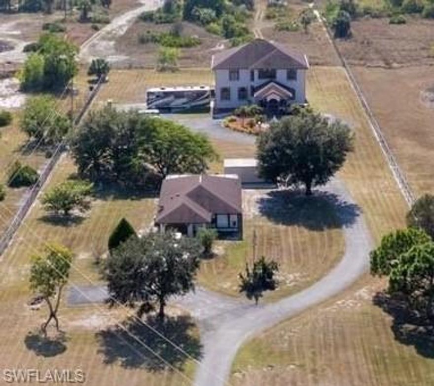 Welcome to an exceptional opportunity in Naples—an expansive NO HOA estate offering over 5,400 square feet of living space, a 4,181 sq ft main residence and a 1,230 sq ft guest home—delivering outstanding flexibility, privacy, and immediate income potential. Set on 2.5 fully fenced acres with an electronic entrance gate, this impressive property features two separate residences, making it ideal for multigenerational living, long term guests, rental income, or a home-based business with room to grow.

The main residence welcomes you with a striking two-story foyer, elegant architectural details, and abundant natural light throughout. The thoughtfully designed layout offers four bedrooms and two full bathrooms upstairs, along with a massive loft providing versatility for a lounge, hobby area, or flex space. The oversized primary suite serves as a true retreat, featuring a spacious bedroom, memorable master bathroom and two large 8' x 7' walk-in closets. Downstairs, you’ll find two additional rooms, including a den or guest quarters and an impressive media room that also functions as a reinforced safe room—a rare and valuable feature.

Outdoors, enjoy a private pool and spa, screened lanai, and—most importantly—peaceful, secure surroundings. A charming fountain at the front entry enhances the property’s welcoming yet grand presence, while the attached two-car garage, paved RV/boat parking area, and additional shed provide excellent storage and functionality. Offering ultimate peace of mind, the home is located in an X flood zone (no flood insurance required), equipped with accordion shutters, two Trane air conditioners approximately seven years young with transferable warranties, and a 2018 roof.

Complementing the main home is a fully equipped guest house offering three bedrooms, two bathrooms, an updated, open-concept kitchen, complete living quarters, along with its own attached garage.

Whether you envision a private family retreat, a work-from-home setup, or an investment property with multiple uses, this estate delivers unmatched possibilities. Conveniently located near the newest Publix shopping plaza, A-rated schools, an easy commute to Arthrex or Ave Maria, this is a distinctive Naples property where space, freedom, and opportunity come together—at a price that WILL NOT last.