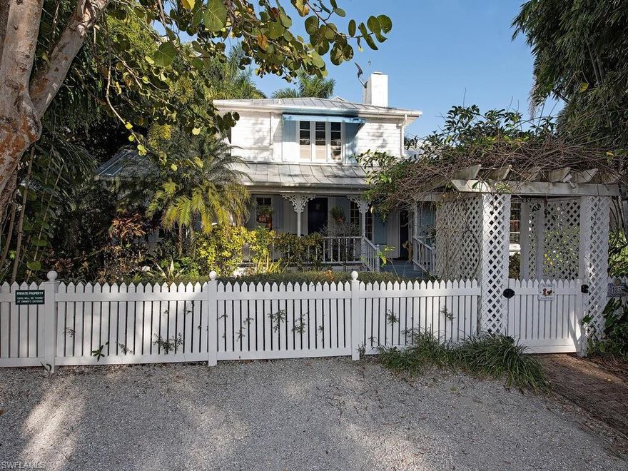 Classic Key West architecture and historic lore combine to make one of Naples’ most iconic cottages. Constructed in 1930 and known historically as The Alamanda Cottage, this majestic beauty is steeped in Naples History. As you pass through the trellis draped in bright yellow Alamanda flowers for which the cottage was named, you will find a quaint façade with front porch perfect for enjoying gulf breezes. Through the graceful entryway, one will find spacious yet intimate living and dining spaces with high ceilings, original pecky cypress walls, wood burning fireplace and fully restored Miami Dade pine flooring.  Adjacent to these spaces is a glorious and updated gourmet kitchen featuring high end appliances.  Glass doors open to the expansive side porch which overlooks a park-like setting with koi pond, garden walks, and magnificent ficus trees that predate the cottage. An addition was mindfully added which includes an oversized two car garage, and a luxurious master suite with 18’ ceilings on the second floor with expansive bath and walk in closet. Old world charm, peerless craftsmanship, celebrated history and tropical splendor continue to live harmoniously at this Naples icon.