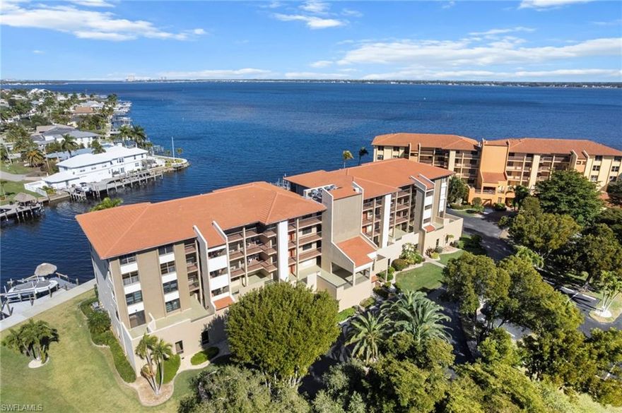 Enjoy panoramic riverfront living with sweeping views of the Caloosahatchee River! PLUS a private boat dock with a 10,000-pound lift, parking garage, and personal storage, all at a great price point for all this condo has to offer. The Rivers Condo is financially secure and beautifully maintained waterfront community where luxury, boating, effortless living, and miles of Caloosahatchee River vistas come together. This impeccably remodeled, fourth-floor corner residence offers a true boater’s paradise just steps from the nearly completed 18-million-dollar transformation of Jaycee Park. Wake to glowing sunrises over the water and unwind each evening with spectacular sunsets from your living room and enclosed lanai. The chef’s kitchen is a standout, featuring professional-grade Viking and Bertazzoni appliances, including an induction cooktop and convection oven, stone countertops, a large breakfast bar, lazy-susan, and high-capacity disposal.  This Kitchen is rarely found at this price point. The spacious owner’s suite provides a waterfront retreat with a walk-in closet, and a private bath. A well-appointed guest bedroom great for family and visitors. The enclosed lanai offers additional living space with inspiring river views. Your private dock includes a 10,000-pound boat lift with remote control, water and electric service, and a large dock box, ideal for serious boating enthusiasts. The community offers a large, heated riverfront pool, elevator access, secure under-building parking, and a personal storage locker. This is NOT A 55+ COMMUNITY, making it ideal for all buyers and excellent for long-term resale. Recent building improvements include a new roof 2024 and a new seawall 2025. Available turnkey, allowing you to begin enjoying the Florida waterfront lifestyle immediately. Directly next door, the revitalized Jaycee Park is becoming one of Cape Coral’s premier waterfront destinations, featuring a scenic boardwalk overlook, inclusive playgrounds, splash pad, beach volleyball, lawn games, food truck court, picnic and gathering areas, a future bistro, performance bandshell, and beautifully enhanced landscaping, all designed to celebrate the river and create a vibrant community hub. This exceptional riverfront residence combines luxury finishes, boating access, resort-style amenities, and long-term security in one of Cape Coral’s most desirable and rapidly improving locations. Located just minutes from dining, shopping, and entertainment, including Starbucks, Target, Publix, and Cape Coral’s best restaurants, this condo is also close to the largest and most ambitious projects including Slipaway, The Cove at 47th, Bimini Square, and the 300-million-dollar Yacht Club renovation and Cape Coral's only Beach just minutes away!
