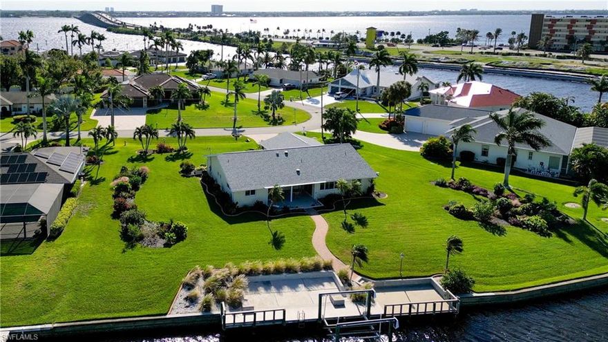 LOCATION! LOCATION! LOCATION! . . . 198' of water frontage on the 200' wide sailboat access Mandolin Canal, just 6 houses from the river. Enjoy breathtaking sunsets from this lovely home situated on ½+ acre of prime waterfront property.  This immaculate home is perfect the way it is, & the gardens are tremendous w/space to add a pool. This Cape Cod inspired home offers a neutral palette. Plan has a formal living & dining area plus a dining nook & family room which overlook the lanai & water. The kitchen was remodeled in 2021, features include white wood cabinets, quartzite countertops, SS appliances & built-in desk. The main bedroom sliders open onto the lanai & windows overlook the water. Bdr 2 is located on the water & bdr 3 shows as an office. Updated bathrooms. Plantation shutters throughout. Impact resistant windows. Dock & 10K boat lift w/new motors, cables, & carpet. Flooring is a tasteful mix of tile, terrazzo, & carpet. SE Cape has several restaurants, lots of shopping & the Cape Coral Yacht Club. Easily visit the renowned beaches of Fort Myers, Sanibel & Captiva. If you dream of building a new home, there are few properties w/this location & size (lg enough for 2 homes).