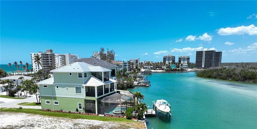 This 3 Story Bonita Beach bay front home offers everything for the perfect Florida lifestyle including: a location so close to the Gulf that its wide long bay views offers the same clear turquoise water, a 14,000 lb boat lift for premier deep water boating minutes from the Gulf pass & a boat ramp at the end of the street, a beach access that is a short walk across the street to beautiful Bonita Beach (which was recently re-nourished and widened), and an immaculate 4 bedroom 4 1/2 bath Coastal style home with tropical screened in swimming pool and spa sitting right on the bay that is move in ready and turnkey furnished. Features include an open floorplan where kitchen, dining room and great room open to a large covered lanai via a wall of sliding glass doors.  The lanai offers the ultimate views of the bay to north, east, and south. The kitchen features a large sit at island, custom cabinets, quartz countertops and induction range.  The 3 guest rooms with en suite baths feature bay or partial Gulf views.
The master suite encompasses the whole width of the third floor right over the water with amazing bay views,  beautiful white wood vaulted ceilings, sitting area that leads to the private covered lanai. The master bath has a separate shower, free standing tub, his & her vanities and large closet. Amenities include private elevator, volume ceilings, Coretech flooring, oversized garages, Air conditioned storage, large pool lanai with entertaining area, impact glass, electric shutters, metal roof and stucco finish.  This bay front come offers many options: a great full time residence, a perfect winter residence, a luxury rental property (with no rental restrictions and no HOA fees) or a combination of personal use and rentals to provide income.