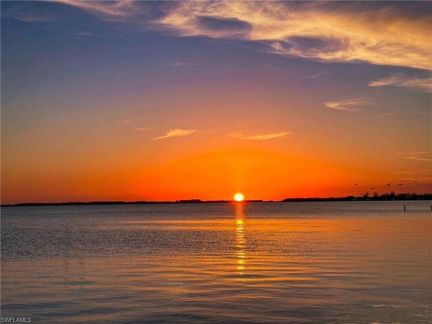 Riverfront Home in the Yacht Club. Dolphin Drive is the BEST RIVERFRONT street offering Southern Exposure and the widest river views. Walking distance to Cape Coral’s only beach combines boating, beach access, and luxury waterfront living in one home. Built in 2009 by Paul Homes, this impressive residence sits on a large .36 acre riverfront lot and offers 3,597 SF with 4 beds, 3 full baths, and 3-car garage. The open floor plan captures water views from nearly every room and features soaring coffered ceilings, crown molding, and details throughout. The expansive living room opens directly to the pool area. The large kitchen features a massive center island with bar seating, ideal for large families & entertaining. The 1st floor Master Suite offers breathtaking views of the river. Imagine waking each morning to the sunrise over open water. The spacious bath features dual vanities, a tub, and a large walk-in shower. A junior suite also offers river views and a walk-in closet, while additional guest bedrooms provide comfortable accommodations for family and visitors, or potential vacation rental opportunities. Upstairs loft-style flex space with a full bath offers endless possibilities and be a home office, media room, billiards, guest suite, or even an upstairs master. The upper level also includes its own screened balcony! The outdoor area is designed for the Florida lifestyle. Enjoy a private pool and spa, paver deck, an outdoor kitchen with a grill, and a covered truss entertaining space. The SOUTHERN EXPOSURE provides full daytime sun across the pool and expansive river views! The private dock offers immediate boating access with no canals, no bridges, and no locks. Simply step out to your boat and be on open water within seconds for fishing, cruising, and waterfront destinations. Many riverfront streets only look across the river and face East. Dolphin Drive faces South-Southwest (daytime sun on pool & sunsets every night) and looks down the length of the river for a big view.  It is the closest riverfront street to the beach, and no major boat channels allow for privacy in your pool area w/out boat traffic behind the house. 2 Spas! One integrated with the pool & a standalone Marquis Spa included! NEW METAL ROOF 2024, hurricane-impact windows and doors, shutters on the rear lanai, and 3 AC’s. The home was built under newer (2009) construction standards and experienced no water intrusion during hurricanes. Located within Cape Coral’s most dynamic waterfront redevelopment corridor, the property is moments from the Yacht Club’s 300-million-dollar redevelopment, which will bring new resort-style pools, marina expansion, waterfront dining, boutique retail, and public gathering spaces. Nearby destinations include Bimini Square, The Cove at 47th, Slipaway Marina, Tarpon Point Marina, and The Westin Cape Coral Resort. Enjoy waterfront dining at Gather, Marker 92, Rumrunners, Pinchers, and numerous new restaurants opening throughout South Cape.