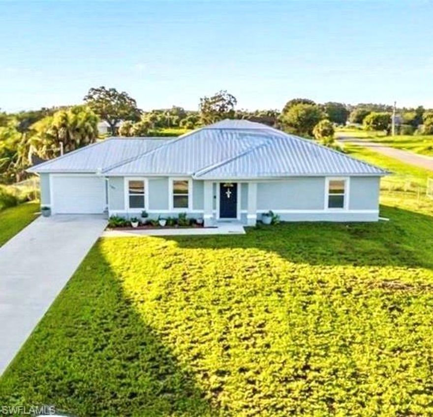 Modern Comfort. Family Friendly. Freedom to Live Your Way.  Welcome to The Calico Estate, a beautifully designed 3-bedroom, 2-bath home built in 2021 on an oversized fenced corner lot in desirable Port LaBelle. This modern Florida residence blends timeless design with everyday functionality—offering the best of both worlds with no HOA or deed restrictions.  Step inside to a bright, open-concept living space featuring a coffered ceiling, laminate wood flooring throughout, and custom barn doors that add a warm, rustic touch. The spacious living and dining areas flow effortlessly into a chef-inspired kitchen with granite countertops, stainless-steel appliances, and crisp white cabinetry, creating the perfect setting for family gatherings or relaxed entertaining.  The primary suite offers comfort and privacy with a large walk-in closet and a spa-style bathroom showcasing granite finishes, designer tile, and elegant lighting. Both bathrooms are tastefully updated with contemporary fixtures and finishes.  Step outside and enjoy the freedom of a fully fenced yard—let the kids and pets roam free—with ample space for a future pool and still plenty of room to play, garden, or entertain. The long paved driveway and attached garage provide added convenience for parking and storage. Experience the privacy and peace of LaBelle, with shopping, dining, and everyday conveniences just minutes away. Located close to schools, parks, and the scenic Caloosahatchee River, this home perfectly combines small-town tranquility with modern amenities.  Whether you’re a first-time homebuyer, growing family, retiree, or savvy investor, 1180 Calico Street delivers comfort, quality, and value in every detail.