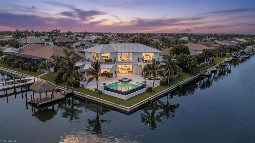 Waterfront 2018 custom-built luxury estate located in the highly sought-after SW Cape Coral, just off Surfside Blvd. This rare gem is perfectly situated at the end of a cul-de-sac, offering over 190 ft of Gulf-access waterfrontage with stunning intersecting canal views and a northern/northeastern rear exposure. Designed with meticulous attention to detail and modern finishes, this home embodies Florida's finest lifestyle, with boating, fishing, golfing, and easy access to marinas, shopping, airports, and beaches. Inside, you will be greeted by abundant natural light, serene water views from every angle, and impact windows throughout. The home is fully equipped with Savant smart home technology, seamlessly connecting the TVs, alarm security system, and lighting. The spacious and open gourmet kitchen features top-of-the-line appliances: the oven and grill are Wolf, and all refrigerators and the wine cooler are Sub-Zero, and is complemented by a bar and a butler's pantry. All countertops are quartz in the kitchen and bathrooms. The oversized primary suite is conveniently located on the first floor, offering direct access to the patio, a boutique-style closet, and a spa-inspired bathroom. Upstairs, a spacious loft awaits, ideal for a home theater, game room, or relaxation area. The second floor also features a second primary bedroom and two additional bedrooms, each with private balconies to enjoy the breathtaking views. The outdoor space is an entertainer’s paradise, boasting an infinity-heated pool, a brand-new 2024 tiki hut, a fully equipped summer kitchen, and a fenced patio. Whether hosting gatherings or unwinding after a long day, this home’s outdoor oasis delivers the ultimate Florida experience. Don't miss this rare opportunity to own a trophy property with direct Gulf access in one of Cape Coral's most desirable neighborhoods. Schedule your private showing today