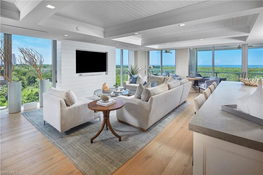 Southwest corner end unit provides an abundance of natural light and expansive views of the preserve and Gulf of Mexico beyond. Tastefully designed with beautiful, warm, wood floors, custom ceiling treatments and ship lap walls, this unit has an understated beach elegance. The open kitchen features a large center island with thick Quartz countertops, a natural gas range and all surrounded fully inset white shaker cabinetry.  The stylish bar island creates separation while offering plentiful storage and 2 wine coolers, ideal for entertaining. The easy flowing 01’ floorplan offers privacy for the main bedroom while guests have four spacious suites to call their own.  Spend evenings on the modern glass railing balcony and watch the sun set over the mangroves and sink into the Gulf, all season long. Mystique is the most luxurious building in Pelican Bay and residents will appreciate the exclusive amenities, including 24-hour security, gated entrance, spaces for 3 cars, separate storage and an elevator straight to your private foyer, all while still having access to all Pelican Bay has to offer.