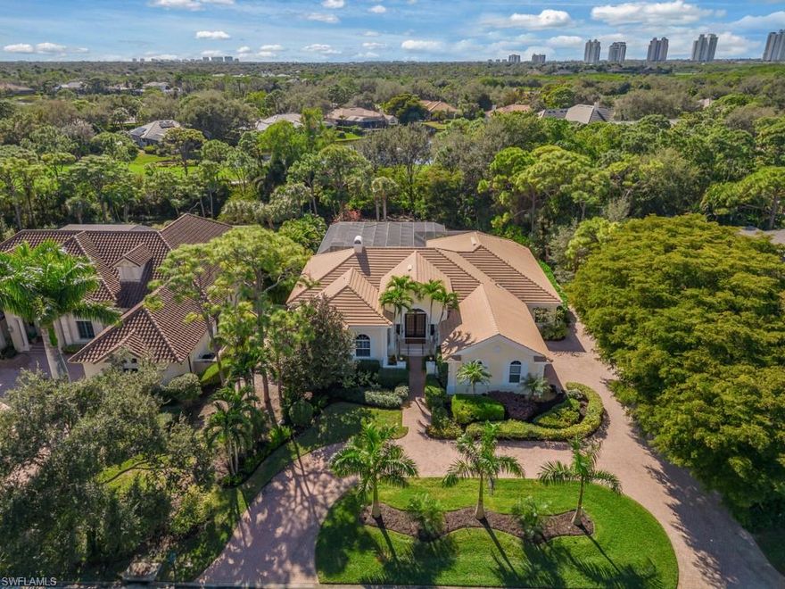 In the Ridge section of Pelican Landing, where homes are rarely available, this impeccably maintained estate home offers refined Florida living with southern rear exposure and peaceful private views. The light-filled, open floor plan features volume ceilings and seamless indoor–outdoor living that opens to an expansive screened lanai, perfect for entertaining. Outdoor living is second to none, with a private pool and spa, a full outdoor kitchen, and lush, mature landscaping that provides abundant privacy. The pool area offers tranquil views and ample space for sun and shade. Inside, the living room showcases coffered ceilings, a fireplace, and pocketing sliding glass doors for the ultimate Southwest Florida lifestyle. The kitchen includes stainless steel appliances, a water filtration system, dry bar with a wine cooler and a generous panty for storage. The spacious primary suite is a true retreat with volume ceilings, private lanai access, dual vanities, a jetted soaking tub, a walk-in shower, and a custom walk-in closet. A flexible den/home office easily functions as an additional guest room. This residence features newer A/C systems, a 2019 roof, updated LED lighting (2025), and an oversized 3-car garage. Pelican Landing offers an impressive amenities array: a top-tier tennis program, private beach park accessible by water taxi, Spring Creek kayaking and canoeing, a vibrant community center, a state-of-the-art fitness center, sailing, bocce, pickleball courts, and miles of scenic walking and biking trails. Golf enthusiasts can explore membership opportunities at The Nest Golf Club. Convenient access to Naples, Southwest Florida International Airport, Coconut Point, Miromar Outlets, and Gulf beaches completes the lifestyle. Don't miss this impressive estate home in one of Pelican Landing’s most desirable enclaves for an exceptional Florida lifestyle.