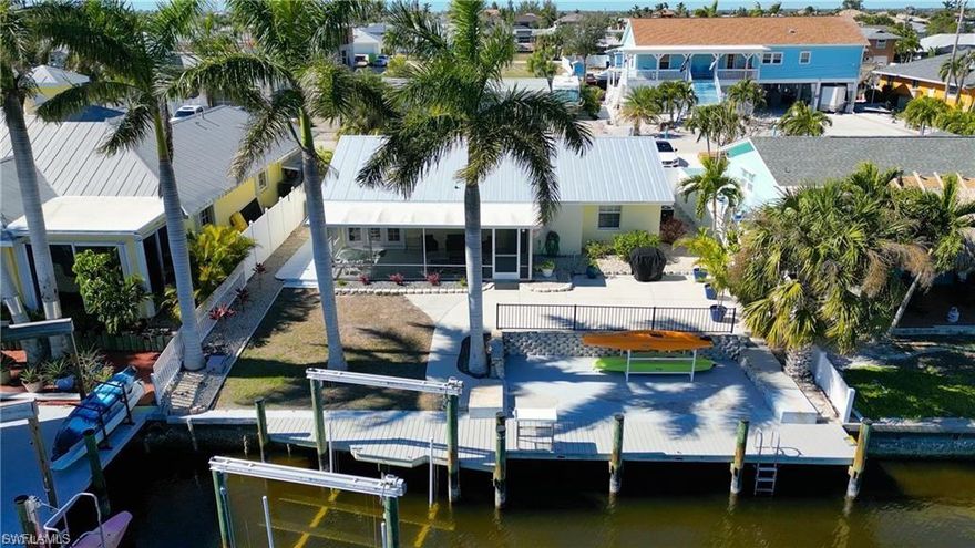 HUGE PRICE REDUCTION!!!!! TURNKEY READY TO MOVE IN ISLAND HOME IN SOUTHWEST FLORIDA! Live your best island life in this beautiful fully furnished, direct deep-water access intercoastal island home! AND as a money saving bonus, the affordable FLOOD POLICY IS TRANSFERABLE! This spacious home comes fully furnished and TURNKEY! This island gem offers a very well thought out open floor plan with a master suite, guest suite, full bath and a flex space that can be used as an office or small den perfect for remote work or additional guests. The entire home has been tastefully renovated with an island flair including, luxury vinyl wood plank tile throughout, fresh paint, updated kitchen with stainless appliances and granite countertops. The new sliding glass door in the dining room area really brightens up the living space and seamlessly connects the indoor and outdoor living spaces! The outdoor living space of this home really makes it special! Watch the dolphins and manatees play or take in one of the famous Matlacha sunrises and sunsets from the covered screened lanai. The rear of the home offers several patio spaces to enjoy with plenty of room for a pool! The dock space makes boating a breeze complete with 10k boatlift and composite dock. Surrounded by incredible nature, world-class fishing and pristine beaches, the open waters of Matlacha Pass are just a short 10-minute boat ride away! If paddling is your pleasure, this property is located on the Calusa Blueway Paddling Trail! This home is located in Matlacha Isles at the entrance of Matlacha and Pine Island. Location offers a perfect balance of privacy and convenience. Running to "town" (islanders name for the mainland :)) is a breeze while all that Pine Island and Matlacha has to offer including cool and funky boutiques, great local waterfront restaurants and entertainment remain at your fingertips! Exterior attributes include double driveway for extra parking, open storage space on either side of the home and a 2023 metal roof. Make sure to check out the drone footage to realize the stunning beauty of this location! Come see this home today and start Living the Island Life!