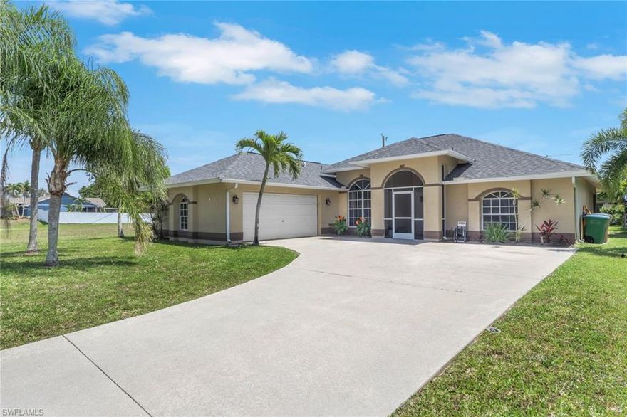 NOT A FLOOD ZONE! Beautifully updated and with southern rear exposure in a convenient part of SE Cape Coral.  Easy access to Veteran's and the Midpoint Bridge, This great room style home is move in ready and has City Water and Sewer in and Paid.  Large open kitchen with granite counter tops, lots white shaker style cabinets for storage, Stainless Steel appliance package and is a great place to entertain family and friends.  Bedrooms has updated barn doors, owner's bath has custom tile work and frameless glass shower doors, matching granite counters and dual vanities.  Large under truss screeded in lanai for enjoying the weather.  Outside has mature Floritam lawn, automatic sprinklers, and mature tropical landscaping.