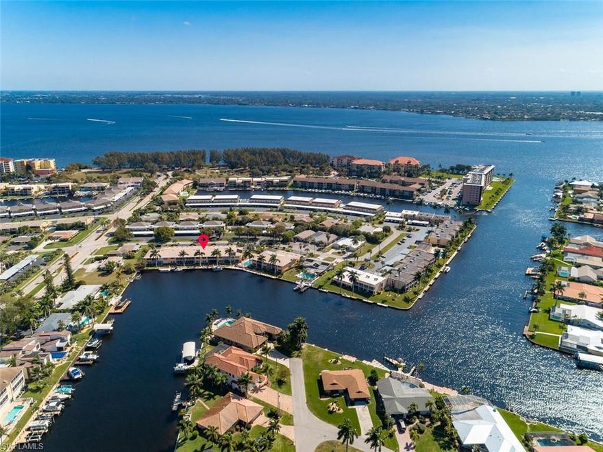 PRISTINE! One of the BEST VIEWS in the Cape! This intersecting canal view boasts a western exposure for ultimate sunsets. Rarely available - 2nd Floor, 3 bed / 2 bath condo is less than 6 minutes to the RIVER (no bridges). It's nestled in a highly sought after quiet neighborhood on a beautifully landscaped property. Within walking distance to Jaycee Park & close to downtown Cape. One of the very few complexes that offer garages. Unit is totally updated (open floor plan) unlike most of the units within this complex.Dock rebuilt in 2014 & bldg. repainted in 2019; new gutters 2020, new roof 2005 (all assessment paid) plus unit has been re-piped. New high efficiency AC 2018, all new woodwork / crown molding in 2010 with new doors & hardware. Appliances replaced in 2013 & new ceiling fans in 2019. Overhead garage doors (including service doors) were replaced in 2013 (all assessments paid). Impact resistant windows (tinted windows & sliders) incl roll-down “sun” shades & plantation shutters throughout. Large lanai & laundry room w/cabinetry & slop sink. Water IS INCLUDED in HOA (fully funded reserves). Boat dock space available (30' total length of space). Make an appointment today!