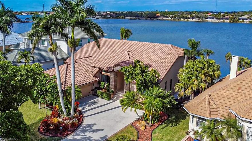 Paradise found! Huge price reduction by motivated sellers. Seller financing available. LAKEFRONT and Direct GULF Access inside a gated community! One of the most unique communities in SWFL because of all it offers. Not only will you love the spectacular water views from this lakefront home, but the two spring-fed lakes are ideal for boating, kayaking, fishing, water skiing, swimming, and much more. Additionally, all residents have GULF ACCESS via a private boat ramp inside the community. The home is Upscale and immaculately maintained and is being sold furnished,  2459 Sq Ft of living area, and features 3 bedrooms, an office/den (which used to be a bedroom), two full baths, high ceilings, 8ft sliders, impact windows, electronic roll down screens on lanai, screened lanai with custom built outdoor kitchen/bar with a pizza oven, perfect for entertaining. Sandy beach in backyard. The living room and kitchen areas are all glass/window to provide a view of the lake that extends out over 1300 feet. The guest bedrooms are ensuite, perfect for guests, nanny, or MIL suite. The office/den is right off of the master and could be used as a nursery or bedroom. Recently renovated and updated with a NEW AC system installed in May 2024. The home sits mid-center on the lake for the best water views, and it is one of the few homes in the Harborage with no homes/buildings across the street. Mature landscaping with palm trees, fruit bearing trees and plants. The community has two lakes for all types of on the water fun. Step right out the back and you can swim, water-ski, jet-ski, knee-board, fish, and kayak, all right from your own yard. Plus all residents have Gulf access via the community boat ramp located in the community boat storage yard. Cruise down Mullock creek to Estero Bay, Fort Myers Beach etc. Great back bay fishing, or head out to the Gulf. There's a new clubhouse, community pool, tennis and pickleball courts, picnic tables, and a child's playground. Boat ramps to both lakes are conveniently in the center of community. Boat storage included. Convenient location: quick drive to beautiful beaches, as well as retail, restaurants, and the airport.