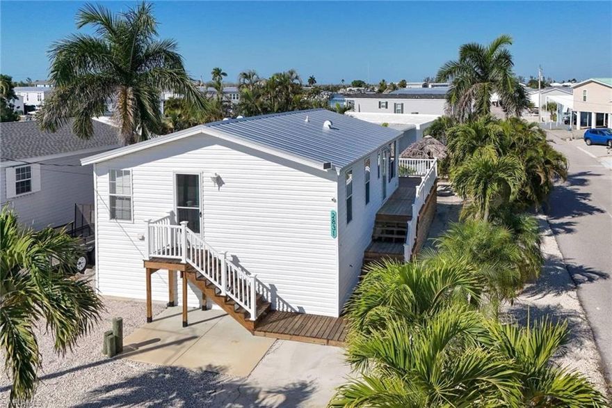 Affordable living in st james city. The old mobile was replaced after IAN with this 2023 2bd 2ba manufactured home. It shows like brand new with a large master suite--vinyl plank flooring--glass face upper cabinets--full width great room. Huge exterior decks surround the north & west sides of the elevated home. There is a rear stairway leading to the courtyard with a tiki hut surrounded by palm trees. new metal roof was replaced after Milton due to flying debris from the surrounding structures. Flood insurance is assumable. Check out the virtual tour?