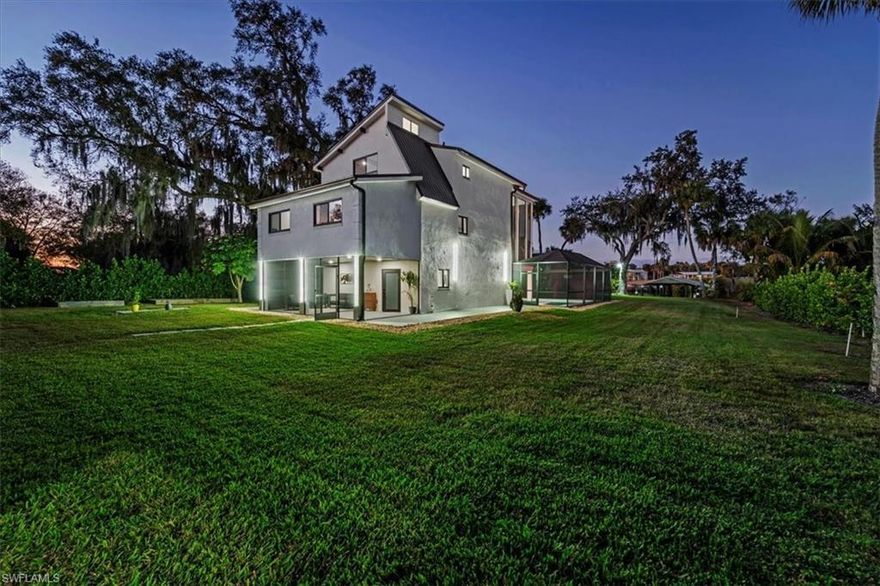 Purposefully designed to capture the breathtaking sunrises & sunsets that define SWFL living!  This contemporary waterfront estate makes a true architectural statement. Situated on 1.36 oak-covered acres, the home embraces its natural surroundings while offering refined luxury with the most recent upgrades.
Soaring ceilings and clean modern lines create a dramatic yet inviting atmosphere, perfectly suited for both elegant entertaining and family gatherings. The kitchen is well equipped with with new applinaces, quartz countertops and upgraged cabinetry perfect for chef of the family.  Dual balconies frame the horizon, offering front-row views of morning sunrises and unforgettable evening sunsets. Modern finishes throughout add a sophisticated touch, while soaring ceilings allow natural light to spill throughout the home.
The newly added saltwater pool anchors the outdoor living experience, complemented by a panoramic views from the screened lanai, with custom lighting, a sun-deck feature perfect for the littles with an added fountain feature and custom lighting.  The boating enthusiast will appreciate the covered boat dock with boat lift and built-in seating area—an ideal retreat for relaxing or just gathering with friends.
This thoughtfully designed residence features four spacious bedrooms and three beautifully appointed baths. Many fruits trees adorn the property with a dual zone irrigation system fed from the river, a rare five-car garage with gym area provides ample room for vehicles, toys, and lots of storage.
Contemporary, refined, and unmistakably Florida—this exceptional waterfront home offers a lifestyle defined by light, luxury, and timeless riverfront beauty.