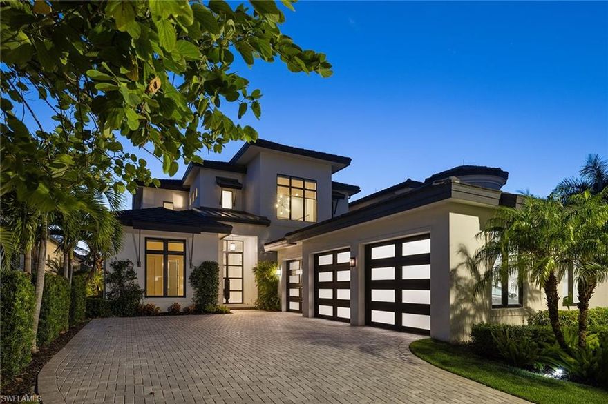 Some homes simply exist. Others are designed to be experienced. Set within the gates of Miromar Lakes—a nationally awarded waterfront community—this architecturally modern home offers a rare blend of clean design, advanced construction, and access to one of Southwest Florida’s most exclusive amenity lifestyles. Built in 2020, the home showcases intentional living at every turn. Ten-foot impact-rated iron doors lead into a voluminous interior defined by clean lines, natural light, and a floating staircase that anchors the space with sculptural presence. A private elevator adds ease across two levels, where the open floor plan balances flow with function.  The kitchen is expertly equipped for everyday living or entertaining on any scale. Double-thick quartz countertops, a waterfall-edge island, hidden pantry, and appliances by Wolf, Monogram, and Asko elevate the experience. Oversized tile flooring, custom cabinetry, soft-close drawers, and curated lighting enhance both form and function.  Retreat to a primary suite that combines lake views with privacy. Details include a custom wall molding, tray ceiling, motorized window treatments, and a custom closet with integrated washer and dryer. The en-suite bath delivers a spa-like escape with a freestanding tub, dual vanities, and frameless walk-in shower.  Upstairs, a vaulted loft, den, and guest accommodations provide space to grow, host, or work from home. Every finish speaks to quality—solid-core doors, impact glass, and smart mechanical systems throughout.
The outdoor space is equally curated: a saltwater gas-heated pool and spa with waterfall, fire pit, and deck jets, all framed by shellstone pavers and a panoramic Clearview enclosure. The lanai’s tongue-and-groove ceiling, summer kitchen, and hurricane-rated motorized screens extend your lifestyle outdoors in comfort and security.
The insulated three-car garage features epoxy flooring, overhead storage, impact-rated doors, and a Mitsubishi mini-split system. Natural gas powers the home’s core systems, adding efficiency and convenience.
Ownership at Miromar Lakes includes access to a 700-acre lake, white-sand beach, championship golf, tennis, dining, spa and fitness center, and an award-winning clubhouse. Set in a community known for excellence and designed for those who expect more, this home offers a refined way of living that’s both effortless and enduring.  Miromar Lakes is also conveniently located near Southwest Florida International Airport, top-rated healthcare, luxury shopping, dining, and cultural destinations—offering seamless access to everything that matters.