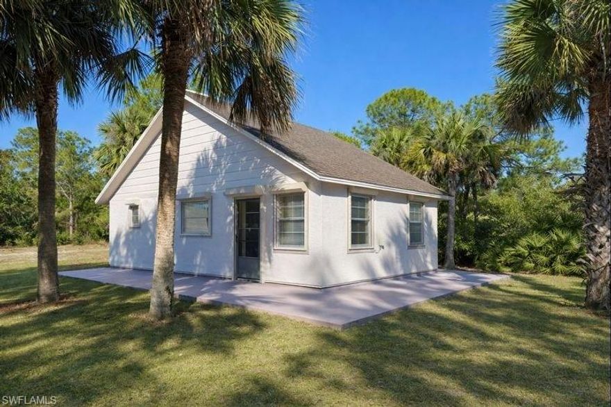 Cozy single family on a mostly cleared HALF ACRE LOT, ROLL DOWN STORM SHUTTERS, NEW CENTRAL HEAT AND AIR IN 2020, NEW DIMENSIONAL SHINGLE ROOF IN 2026, SQUARE D ELECTRICAL PANEL BOX, TANKLESS WATER HEATER, spacious living room as you walk in, kitchen with appliances, indoor laundry room, primary bedroom on the other side of the home, excellent neighborhood atmosphere with larger estate sized homes in the area, nicely landscaped yard with plenty of palm trees for shade, open concrete patio across the front and right side of the property, located just minutes to I-75, Ft Myers and SWFL International Airport. NO FLOOD INSURANCE REQUIRED. LEHIGH IS THE HIGHEST ELEVATION IN LEE COUNTY.