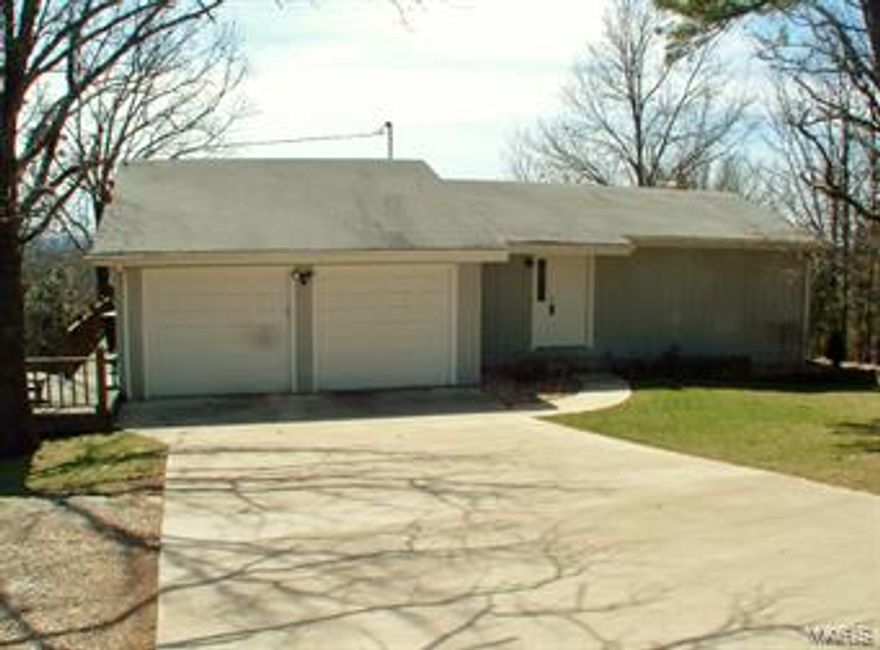 Don't let the front fool you!  This is a wonderfully maintained and loved home with fabulous views from all the windows across the back of the house.  You won't have to do anything but move in and make it your own.  Living room with fireplace and built-ins, formal dining area, beautiful kitchen with TONS of cabinet space, solid surface countertops, double ovens, breakfast area with patio door to the rear deck with beautiful views for miles.  The lower level has a storage room, a big bedroom with 2 closets and an office area that could easily add a closet to make a 3rd bedroom.  Such a charming place!  Outside is a raised garden, circle drive, sprinkler system, easy landscaping and a nice big storage room.  You could sit on the deck with your coffee for hours!