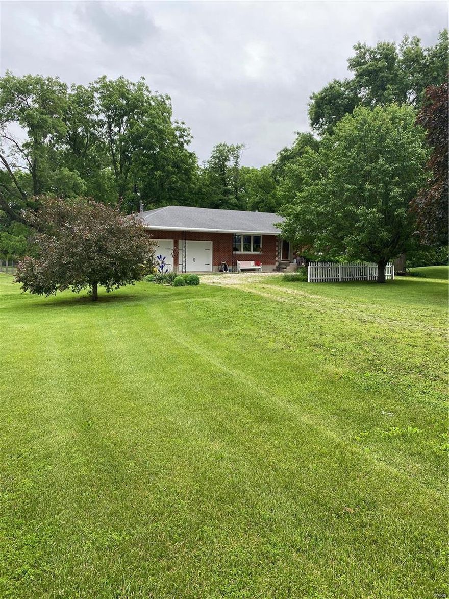 A charming brick ranch sitting on 3 acres right off of black top!!! You can tell this home has been well taken care of. As you arrive you will see the beautiful pond and mature trees. Inside hardwood floors flow throughout the 3 bedroom 1.5 bath home. The kitchen/dining combo has updated electric appliances, with gas hookups available. The main bathroom currently houses the clothes washer and dryer, making the home perfect for single level living. There are additional laundry hookups in the basement. The very clean unfinished basement is currently used as a hobby space and provides an abundance of storage. Off of the back of the home you will find the quaint screened patio looking out to the large fenced backyard, perfect for your morning coffee. The metal outbuilding adds additional garage space for a lawn mower and a shop which features 220 power. The home is located near a gas pipeline serviced by DaCott Gas providing the home low cost natural gas. This is a must see!