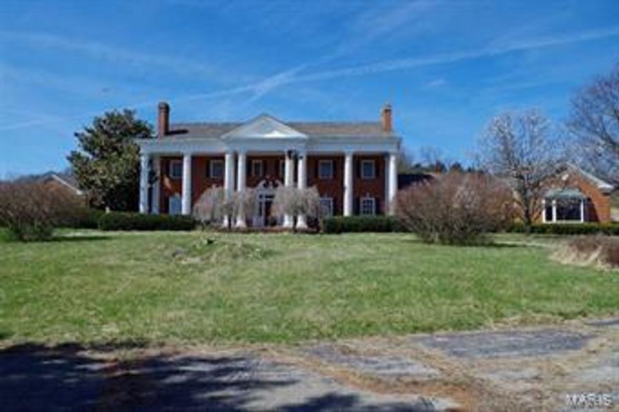 Located in the Rolling Hills of Northern Lincoln County, just south of Elsberry, MO.  The Greek revival style, full-brick mansion w/10 massive columns.  Grand Entry Foyer w/Chandelier & Winding Staircase, Gallery Style Kitchen, Formal Dining, Sitting Room, Large Living Room w/Marble Fireplace, Walnut Paneled Den w/Fireplace, Rustic Trophy Room w/cathedral, exposed wood beam ceilings & massive, stone fireplace. 5 bedrooms, each with private bath and 2 w/Fireplaces on the second story.  Architectural features of the home are crown molding, decorative millwork, inlay paneling, & plantation style windows throughout home. Caretaker’s apt. over the garage, lower level game room, rec room, & bar, in-ground pool & pool house, tenant home.  171 ac standing timber, 66 ac pasture and 8 ac mansion/grounds.  Open, rolling pasture ideal for cattle & horses.  Currently managed for bucks & turkey hunting w/stands & blinds overlooking food plots and waterholes.