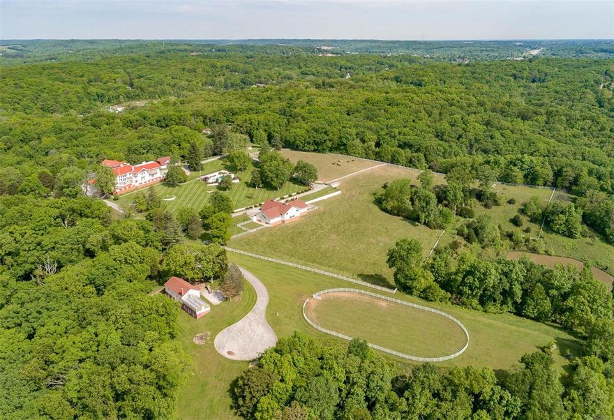 Breathtaking estate on 120 sprawling acres!  Home is perched at the peak of the property overlooking the stunning views of the Mississippi River. The property has a fine equestrian facility housing 12 horses and a riding ring adjacent, lovely pool/spa, as well as a carriage house, greenhouse, and caretakers home.This is an incredible opportunity to keep the property as a private estate or develop part of the acreage. A great room, living room, dining room are all on a grand scale with an amazing staircase reflecting the stature the home deserves. Both levels have complete primary suites with 6 beds/7baths, maids quarters and so much more.  The terrace wraps around the home offering the perfect vantage point for viewing the spectacular grounds, pool, and water. Additional Rooms: Sun Room