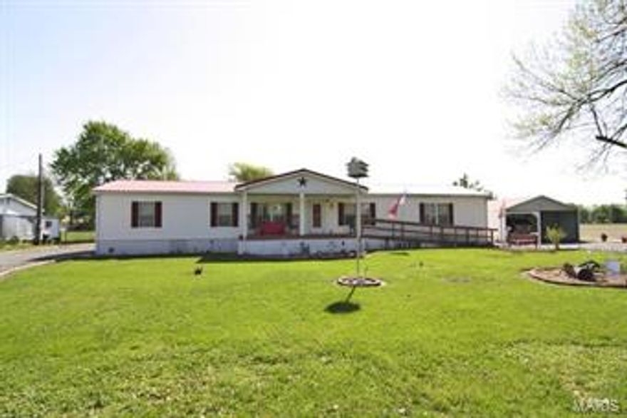 Extremely well maintained manufactured home with nearly 2,000 SF and on approximately 1+/- acre.  60x30 shop with 8' porch that expands 30' across. Outbuilding has central air and heat.  20x26 carport and 12x12 small shop.  Roof on home recently replaced. Low utilities - All electric - Privacy! Approximately 200' from city park, last house at end of town. Only 15 minutes to Cape Girardeau.
