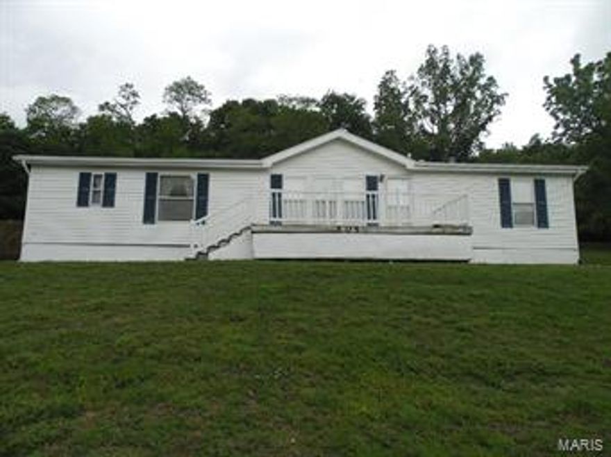 Nice double wide home perched atop a hill awaits its new owner.  This spacious home has 4 BR and 2 BA. and boasts two decks to relax on while listening to the birds sing in the woods just a few feet behind the house.  A huge 40 X 26 detached garage/shed is ideal for a shop.  It is big enough to keep 2 cars and more toys, and has a separate room in the back for parts and more storage.  Look at this before it's too late, priced to sell!
