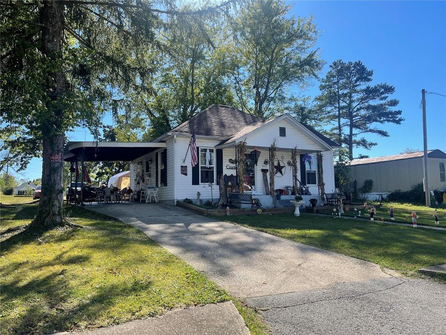 Cottage home with two bedrooms, one bath and attached carport.  Nice sized living room, kitchen with lots of cabinets, pot hanger, smooth top range and side-by-side fridge.  Full bathroom. Vinyl windows. Central air and electric furnace. Utility room. Small fenced in area but the lot is a nice size that runs street to ally way.