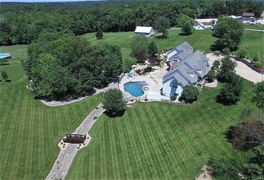 Rockwood schools, Wildwood! Spacious 6 bed, 5 bath custom built ranch with approx 6,000 sq ft of fin living space,  4 car garage on 3 level acres with pool and waterfalls reflects true luxury living!  Entry foyer boasts gleaming hardwood. DR has coffered ceiling & arched entry. Vaulted GR w/hardwood flrs has WB fp w/brick surround & built-ins. Breakfast rm is perfect for that morning coffee. Kitchen boasts granite, center island, planning desk area & custom cabinetry w/crown. Master suite boasts luxury bath w/dual sinks, tub & separate shower. Custom finished LL boasts a Rec Room w/wet bar, FR w/stone fireplace, 3 bedrooms, & 2 full baths. Home also includes Nanny/In-law Suite complete w/bedroom, full bath, living area & kitchenette. Enjoy a vaulted all seasons room that leads to deck overlooking a backyard oasis complete w/pool, hot tub, waterfall & loaded w/incredible hardscapes & landscaping.  Freshly painted rooms! New 50yr Architectural roof '16 Your own par 3 hole & MUCH MORE! Some Accessible Features Additional Rooms: Sun Room