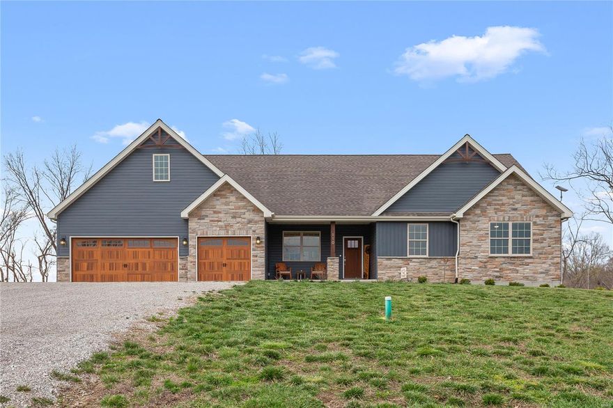 Stunning 2 year-old ranch on 10 scenic acres in Defiance with access to a serene 12-acre lake! Located in top-rated Francis Howell schools, this 2,285 sqft home blends refined style with modern luxury—featuring an open floor plan, soaring vaulted ceilings with wood beam accents, Luxury Vinyl Plank floors throughout the main living area & a striking see-through stone woodburning fireplace. The gourmet kitchen impresses with a large center island, gas cooktop, wall oven & walk-in pantry. The spacious primary suite offers coffered ceilings, a spa-like bath with an oversized tiled shower & a generous walk-in closet. You'll also find 2 additional bedrooms, a home office, 2 full baths, a half bath for you & your guests, & energy efficient geothermal HVAC. Step outside to a stamped concrete patio & spa-ready pad—perfect for entertaining. The 7,200 sqft outbuilding is a RARE find, featuring 400-amp service, bath rough-in & radiant heat-ready floors. A true lifestyle property-don't miss out!