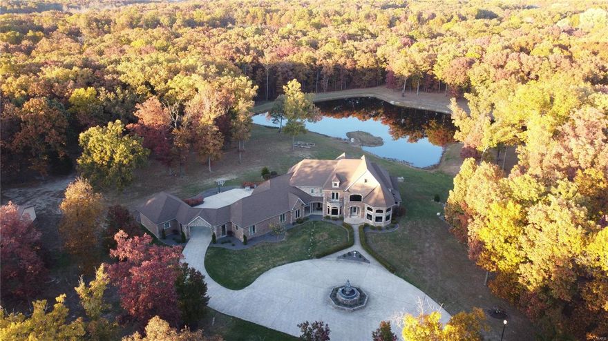 Back up contracts being accepted. Each season brings its own beauty and recreational opportunities when you live at 395 Hwy V in Troy. The 6,000 Sq Ft custom 1.5 story home is close enough to shopping, but private enough to feel like a getaway. Park-like 29 acre property, mostly level and wooded with a large stocked lake. Home features a 5 car garage with 2 of the garage stalls having heating/cooling, plus an outbuilding with high clearance doors. Gated entry, tree lined and lit driveway, landscape, & circle driveway. 2 story vaulted ceilings in the foyer, kitchen, living room, hearth room, breakfast room, and stately office. Floor to ceiling windows bring in natural light and views of the property throughout the home. Main floor master bdrm suite. Dual staircases to upper level with 3 beds/2 baths, loft space, walk in closets, and balcony. LL walk out basement has spacious rec room, bonus room, ½ bath, and 5th bedroom suite. Geothermal heating, new roof 2017 & 1 yr home warranty. Suitable for Bed/Brk