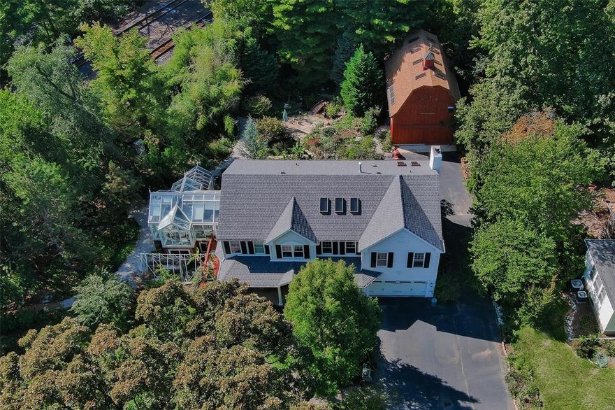 Live in the historic Kirkwood area in a newer 24 yo home with today's modern and elegant amenities but feel like you are in the country on almost an acre with native gardens and trees, a wildlife refuge, water conserving cisterns, and advanced geo-thermal energy use. Walk up the wide flagstone path to the covered veranda on the front facade with ceiling fans and a bead board wood ceiling. Notice the 2 totally unique additions: on the NW side-the 2-story out-parcel barn which can also be used for  projects or overflow parking; and on the SE side-an attached 2-story Victorian greenhouse (heated) for overwintering plants or one-of-a-kind entertaining. The kitchen, FR, wet bar areas were remodeled with carrera marble countertops on the island. The main level has a den/office, and living/dining room full of light. Upstairs is the primary bedroom ensuite(bamboo floors) and LR:a loft area which could be a study/guest area: 3 more BRs. The basement has a full bath, and rec room. Distinctive!